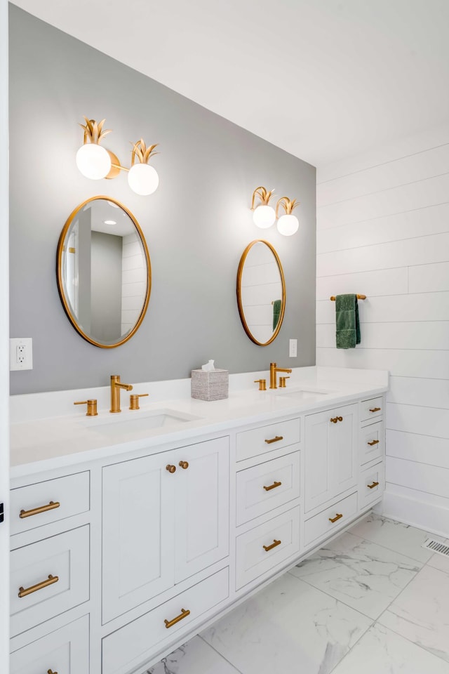 full bath featuring marble finish floor, visible vents, a sink, and double vanity