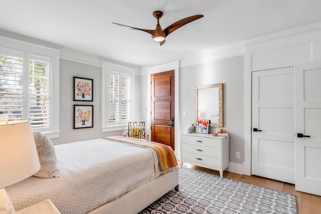 bedroom featuring a ceiling fan, light wood-type flooring, and baseboards