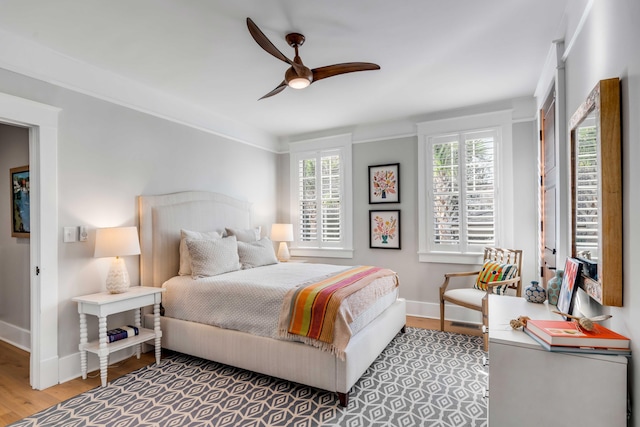 bedroom with ceiling fan, baseboards, and wood finished floors