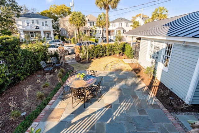 view of patio / terrace with a residential view, fence, and outdoor dining area