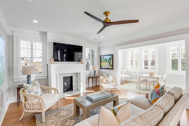 living room with ceiling fan, recessed lighting, a fireplace, wood finished floors, and baseboards