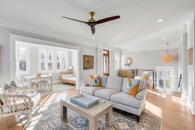 living area with plenty of natural light, wood finished floors, and crown molding