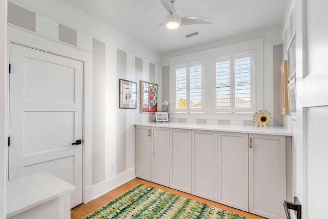 kitchen featuring visible vents, baseboards, ceiling fan, light countertops, and light wood-style floors