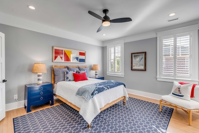 bedroom with baseboards, visible vents, wood finished floors, and recessed lighting