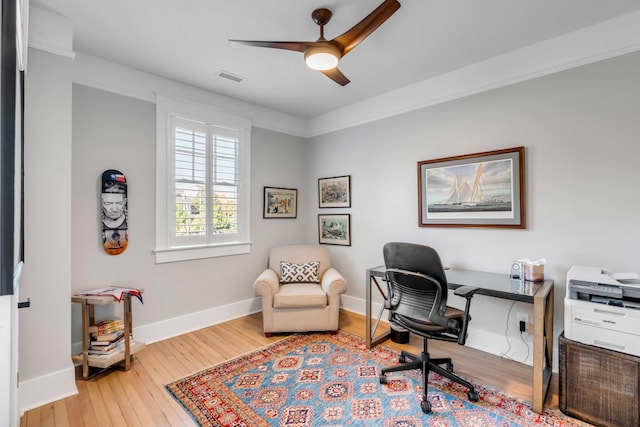 office with a ceiling fan, visible vents, baseboards, and hardwood / wood-style flooring