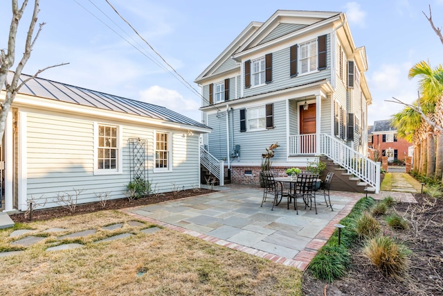 rear view of property featuring metal roof, crawl space, a standing seam roof, and a patio area