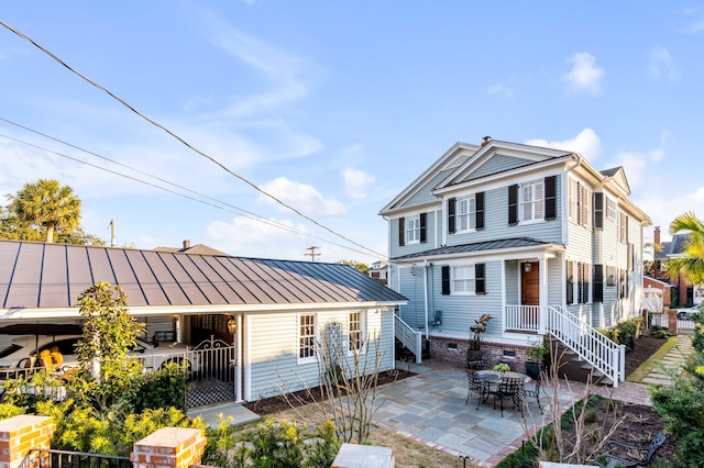 view of front of property featuring crawl space, a standing seam roof, metal roof, and a patio