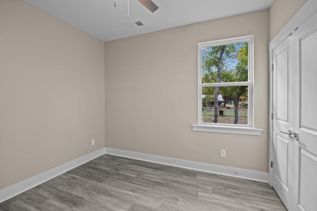 spare room with ceiling fan and light wood-type flooring