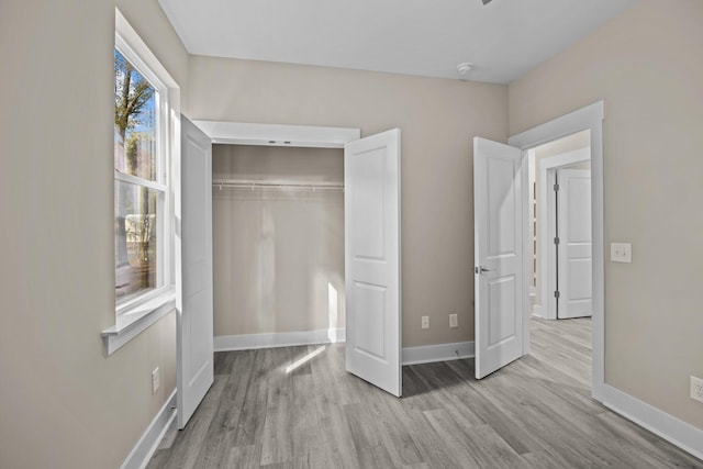 unfurnished bedroom featuring light hardwood / wood-style flooring and a closet