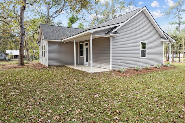 view of side of home with a yard and a patio area