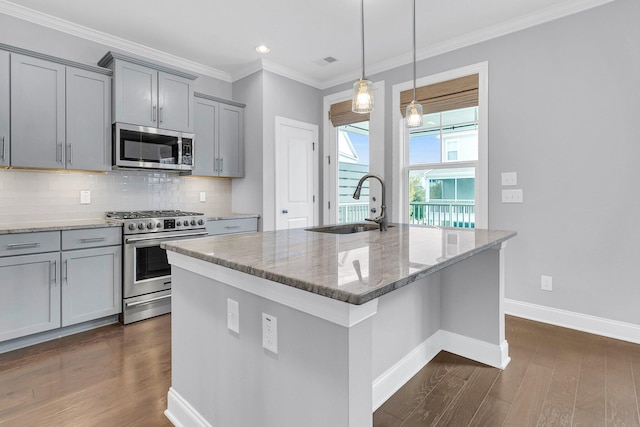 kitchen with a center island with sink, appliances with stainless steel finishes, light stone counters, and dark hardwood / wood-style flooring