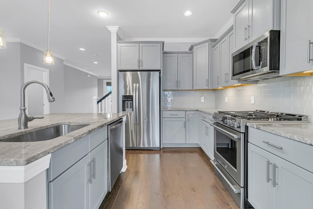 kitchen with dark hardwood / wood-style floors, hanging light fixtures, gray cabinetry, stainless steel appliances, and sink