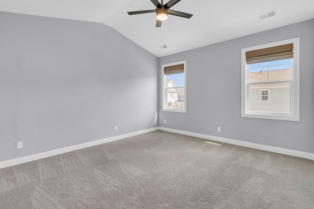 carpeted spare room featuring ceiling fan and vaulted ceiling