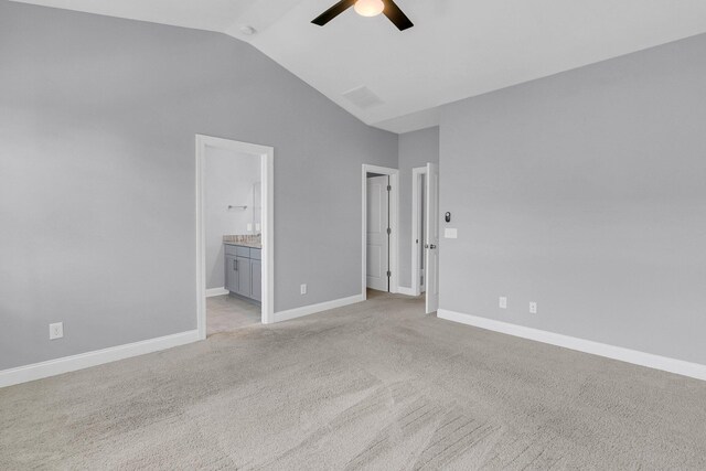 unfurnished bedroom featuring connected bathroom, light carpet, high vaulted ceiling, and ceiling fan