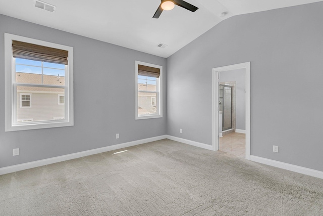 spare room featuring light carpet, lofted ceiling, and ceiling fan