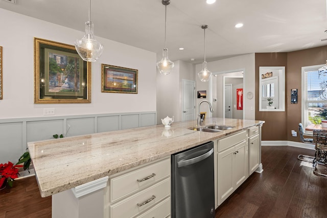 kitchen featuring sink, dishwasher, a kitchen island with sink, and light stone counters