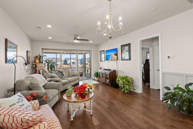 living room featuring ceiling fan with notable chandelier and dark hardwood / wood-style floors