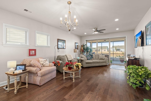 living room with ceiling fan with notable chandelier and dark hardwood / wood-style floors