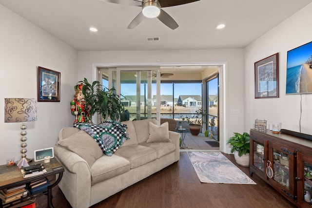 living room featuring ceiling fan and dark hardwood / wood-style floors