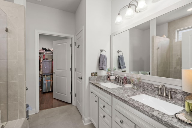 bathroom featuring vanity, tile patterned flooring, and tiled shower