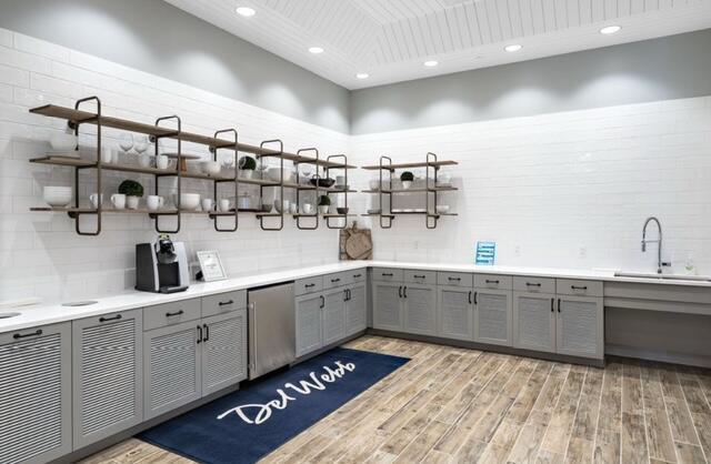 kitchen with gray cabinetry, a towering ceiling, refrigerator, decorative backsplash, and sink