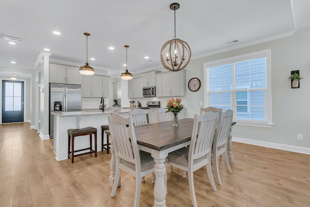 dining space with ornamental molding, light wood-type flooring, and a healthy amount of sunlight