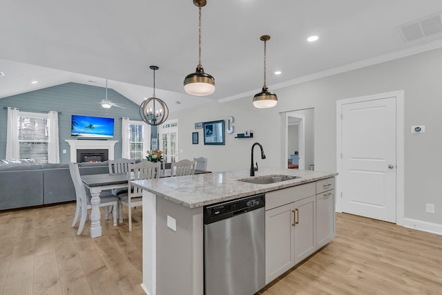 kitchen featuring an island with sink, decorative light fixtures, light stone countertops, sink, and stainless steel dishwasher