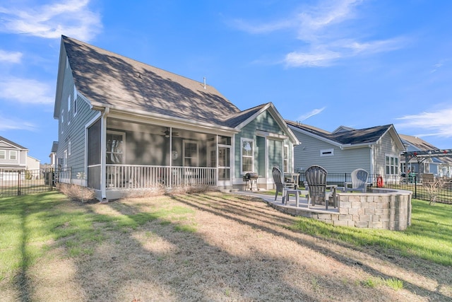 back of property with a sunroom, a lawn, and a patio area