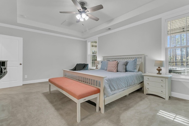 bedroom featuring a raised ceiling, ceiling fan, light colored carpet, and ornamental molding
