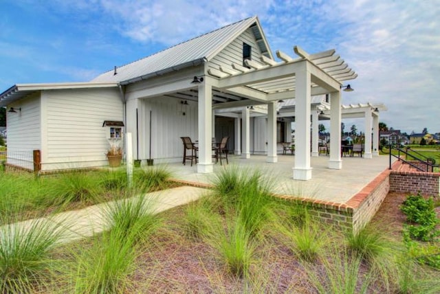rear view of property featuring a pergola and a patio area