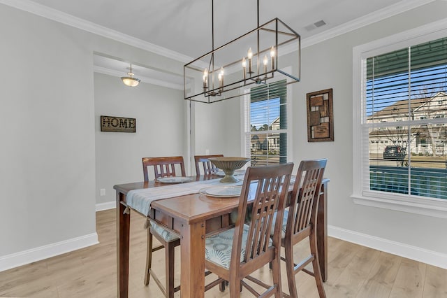 dining area with light hardwood / wood-style flooring and ornamental molding