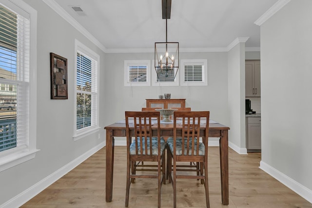 dining area with an inviting chandelier, light hardwood / wood-style flooring, and crown molding