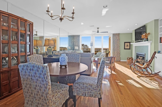 dining room featuring ceiling fan with notable chandelier and light wood-type flooring