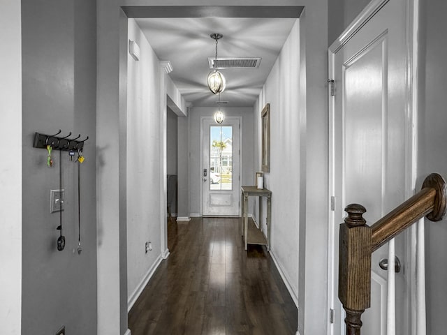 hallway featuring dark wood-style floors, visible vents, and baseboards