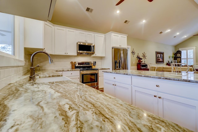 kitchen featuring a sink, light stone countertops, visible vents, and stainless steel appliances