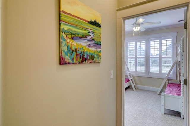 hall with baseboards, carpet floors, and ornamental molding