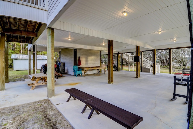 view of patio / terrace featuring a carport, an outbuilding, and stairs