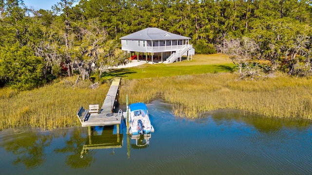 view of dock featuring stairway, a water view, and a yard