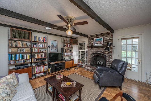 206 Brailsford Rd, Summerville, SC 29485 - living room with a textured ceiling, wood finished floors, beam ceiling, a brick fireplace, and ceiling fan