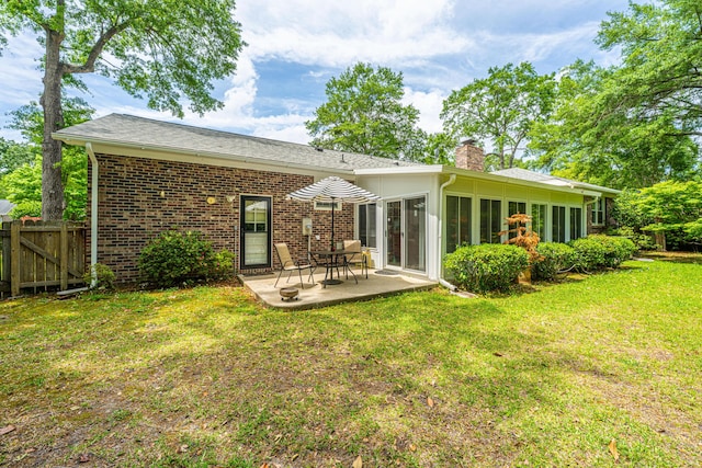 206 Brailsford Rd, Summerville, SC 29485 - back of property featuring a chimney, fence, a patio area, a lawn, and brick siding