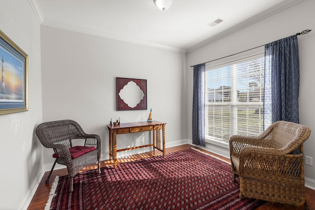 living area with baseboards, wood finished floors, and ornamental molding