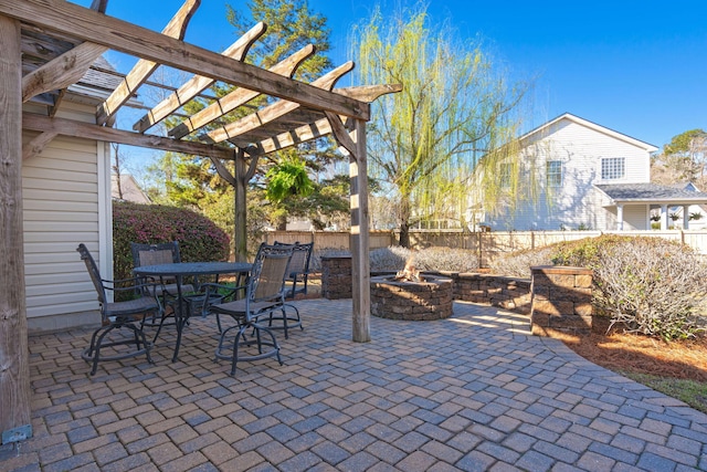 view of patio / terrace with outdoor dining area, a fire pit, fence, and a pergola