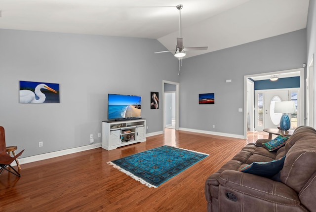 living area with ceiling fan, baseboards, high vaulted ceiling, and wood finished floors