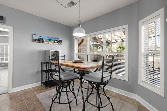 dining space with tile patterned flooring, visible vents, and baseboards