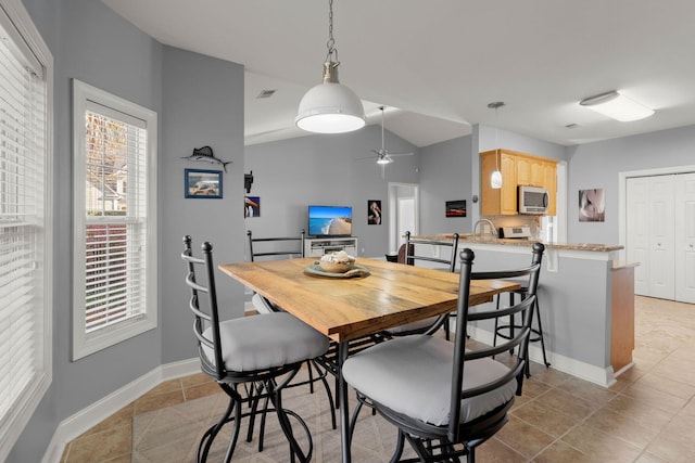 dining room with light tile patterned floors, baseboards, visible vents, lofted ceiling, and ceiling fan