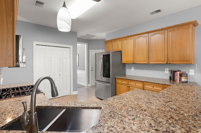 kitchen with tasteful backsplash, visible vents, smart refrigerator, and a sink