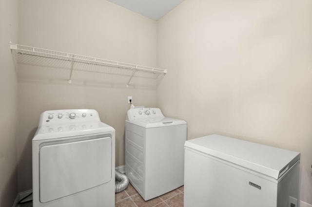 laundry room featuring laundry area, light tile patterned floors, and separate washer and dryer