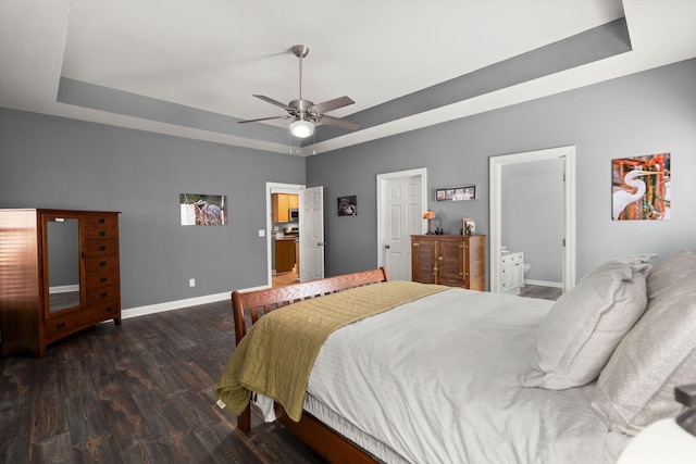 bedroom with a raised ceiling, wood finished floors, baseboards, and ceiling fan