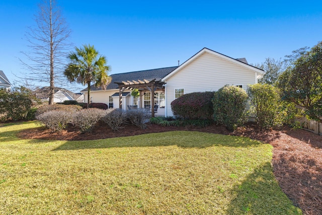 back of property featuring a lawn, a pergola, and a shingled roof