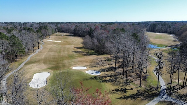 bird's eye view featuring view of golf course and a forest view